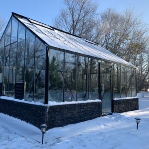 Cottage Greenhouse by Cross Country with glass glazing and sidewall door in the snow