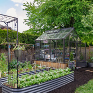 Cottage Greenhouse by Cross Country with mixed glazing in garden with raised beds